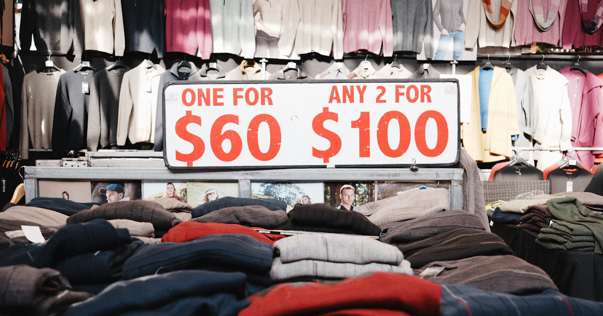 Espositore di maglioni con cartello promozionale "due per cento dollari", esempio di pricing tradizionale a sentimento