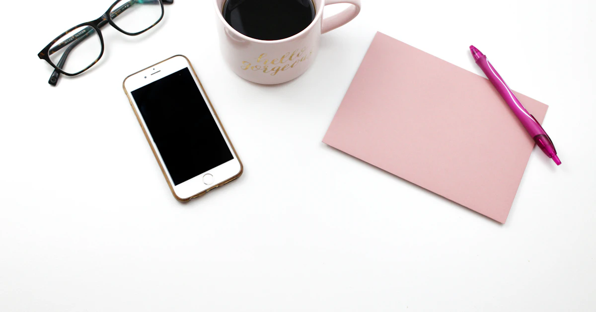 Telefono accanto a tazze di caffè e occhiali, l'attrezzatura essenziale del briefing mattutino