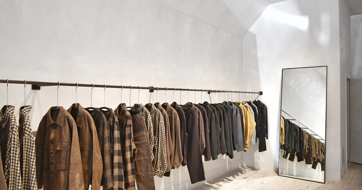 Stanza vuota con parete di abiti su grucce in un negozio di abbigliamento