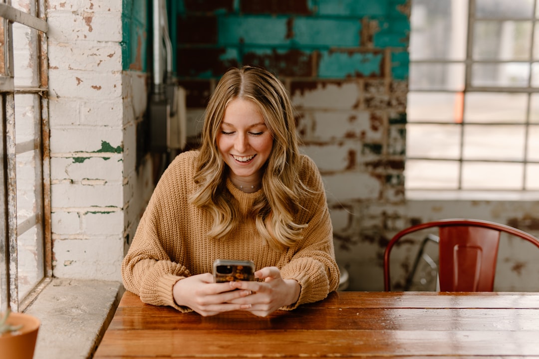 Cliente che riceve una notifica sullo smartphone mentre è seduta al tavolo