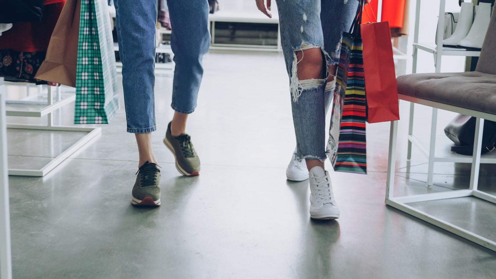 Clienti che escono da un negozio di moda con i sacchetti della spesa