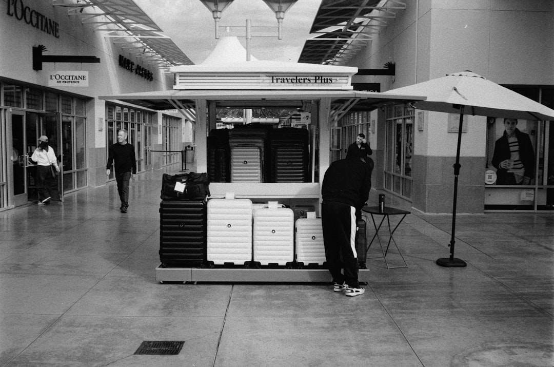 Persone che passano davanti a un chiosco tecnologico in un centro commerciale
