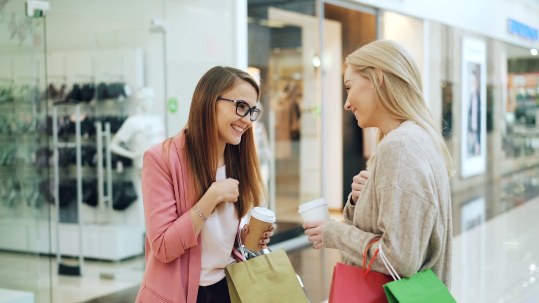 Due clienti con shopping bag chiacchierano in un centro commerciale
