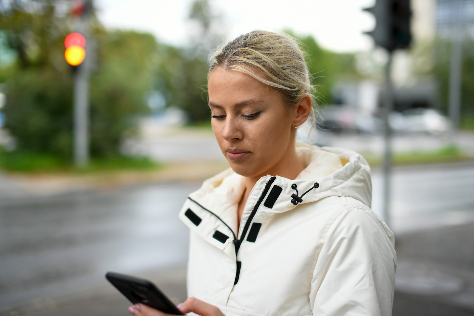 Persona che legge un messaggio sul telefono in strada
